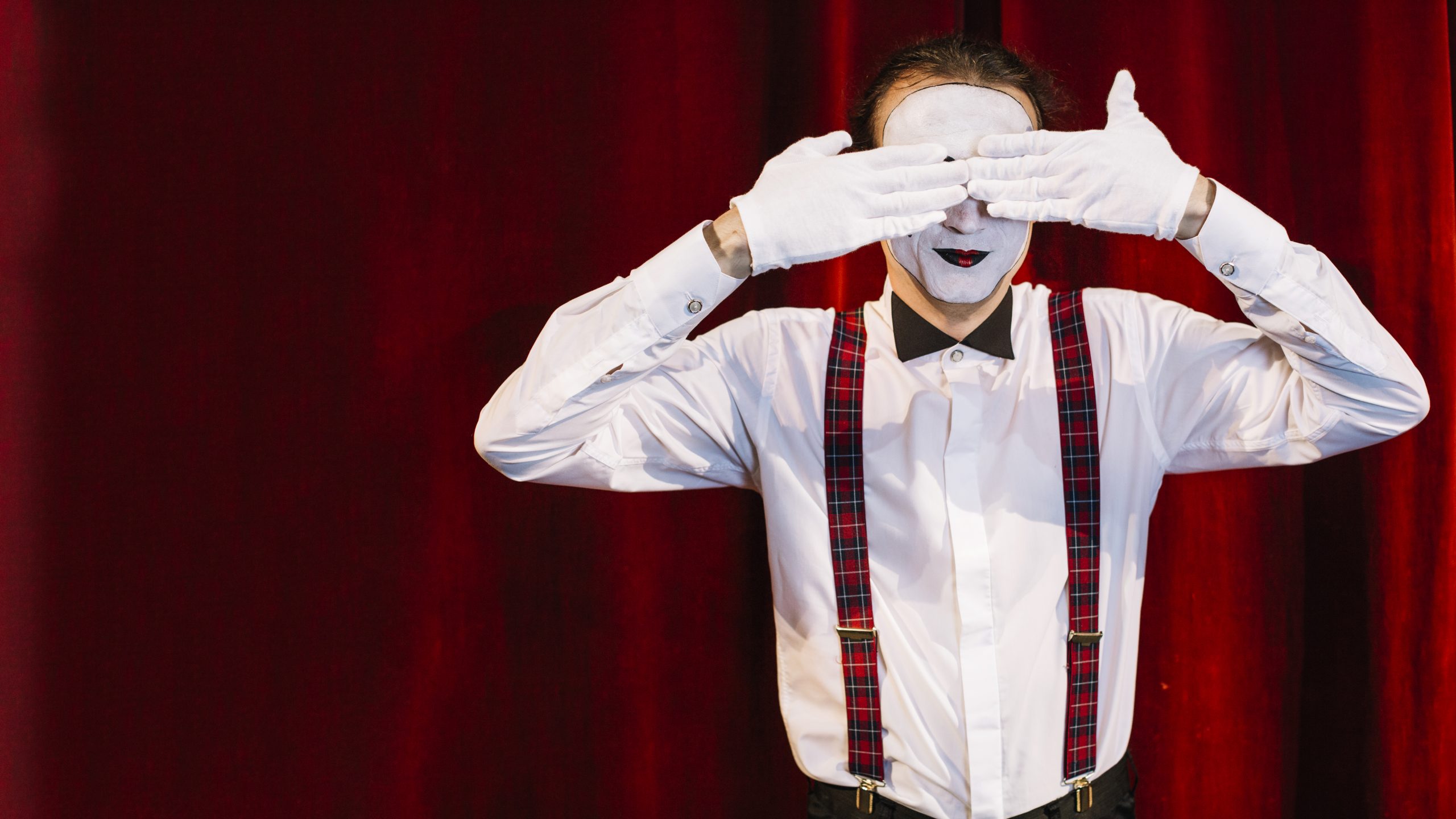hombre mime artista de pie delante de la cortina que cubre los ojos con las manos scaled